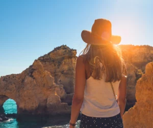 young-woman-looking-caves-ponta-da-piedade-algarve