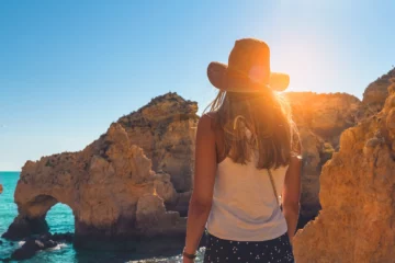 young-woman-looking-caves-ponta-da-piedade-algarve