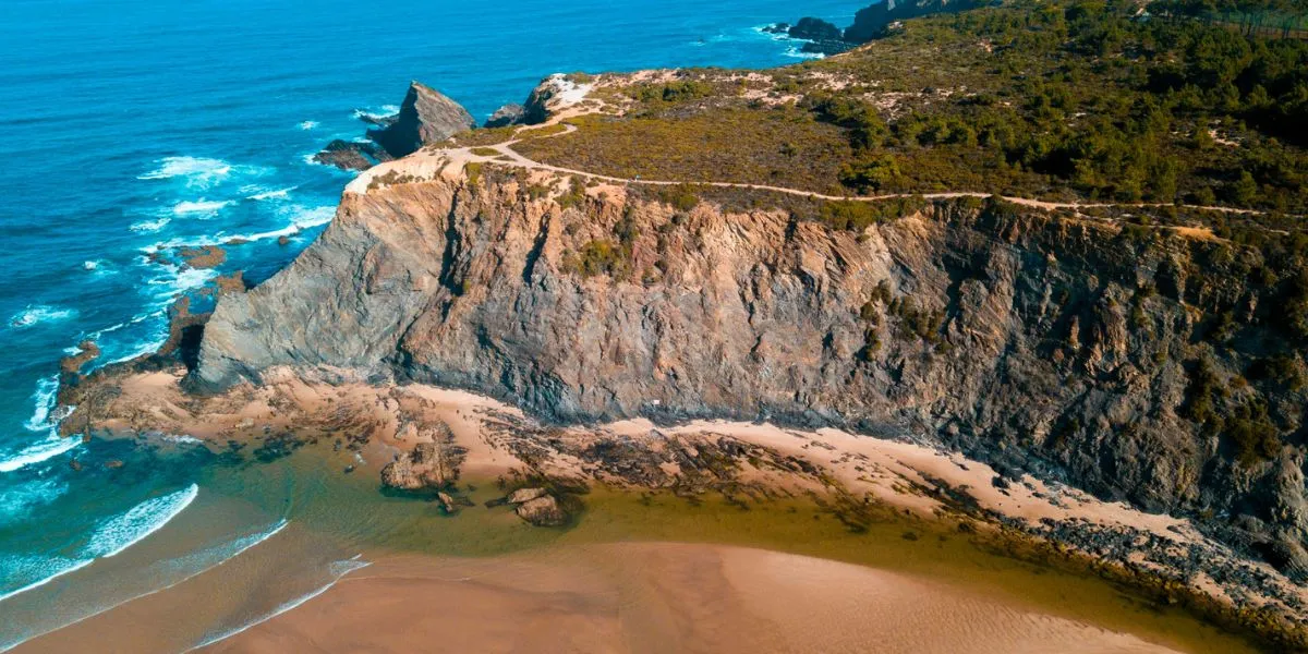 A Dirt Path on the Top of the Cliff Enclosing Odeceixe Beach with the Seixe River Flowing to the Ocean